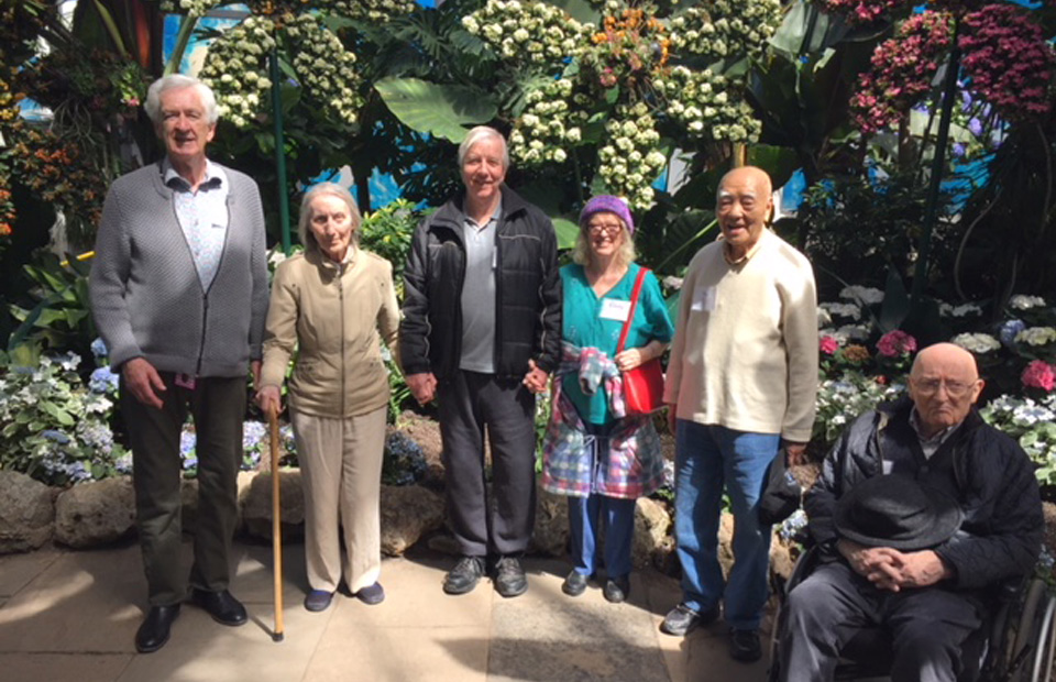 Dixon Hall - Membership group of elderly people standing in front of a garden